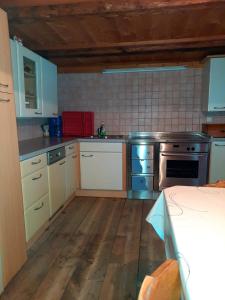 een keuken met witte kasten en een fornuis met oven bij Ferienwohnung Oberpursteinhof in Campo Tures