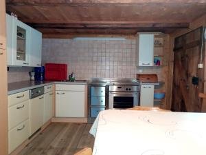 een keuken met witte kasten en een fornuis bij Ferienwohnung Oberpursteinhof in Campo Tures
