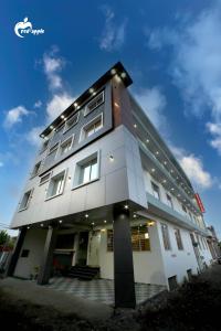 Manī MājraHotel Red Apple Near Railway Station Chandigarh的一座亮着灯的白色大楼