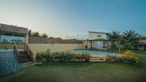 a house with a swimming pool in a yard at POUSADA CENÁRIO IDEAL in Icapuí