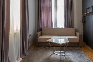 a living room with a couch and a glass table at Luxury Apart Vitosha Boulevard in Sofia