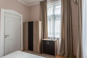 a bedroom with a bed and a window and a cabinet at Luxury Apart Vitosha Boulevard in Sofia