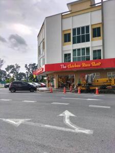 un coche está estacionado frente a un edificio en Kangar Jaya Lodging, en Kangar