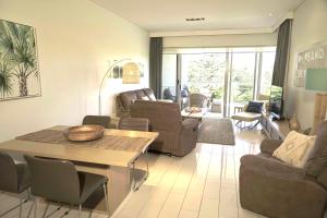 een woonkamer met een bank en een tafel en stoelen bij Peppers Balé Luxury Beach Accommodation Kingscliff - privately let in Kingscliff