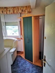 baño con puerta verde y ventana en Gehlberger Landhaus am Schneekopf / Ferienwohnung en Suhl