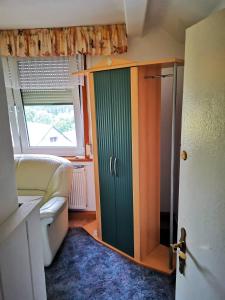 a bathroom with a green door and a window at Gehlberger Landhaus am Schneekopf / Ferienwohnung in Suhl