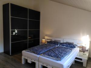Modautal的住宿－Strandurlaub am Felsenmeer，一间卧室配有一张大床,提供蓝色的床单和枕头