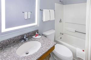 a bathroom with a white toilet and a sink at Super 8 by Wyndham Johnstown/Gloversville in Johnstown