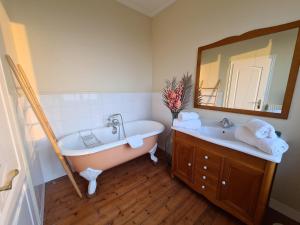 a bathroom with a tub and a sink and a mirror at La Terrasse de l'Estuaire - Honfleur in Honfleur