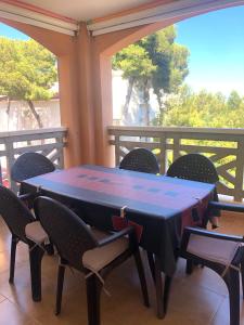 - une table et des chaises sur une terrasse couverte avec vue sur les arbres dans l'établissement APARTAMENTO EDISON,PARKING, PISCINA VISTAS AL MAR, Castellón de la Plana