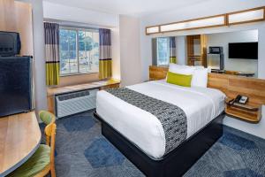 a hotel room with a bed and a television at Microtel Inn & Suites by Wyndham Johnstown in Johnstown