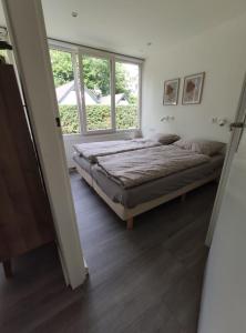 a bedroom with two beds and a window at Vakantiewoning Sjun Limburg in Simpelveld
