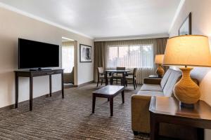 a living room with a couch and a flat screen tv at Best Western Plus Garden Court Inn in Fremont