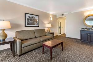 a living room with a couch and a table at Best Western Plus Garden Court Inn in Fremont