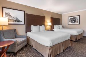 a hotel room with two beds and a chair at Best Western Plus Garden Court Inn in Fremont +23 photos