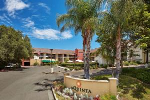 une rue en face d'un hôtel avec des palmiers dans l'établissement La Quinta by Wyndham Thousand Oaks-Newbury Park, à Thousand Oaks