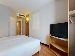 a hotel room with a television and a bed at Ibis Bratislava Centrum in Bratislava