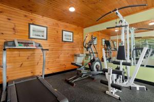 un gimnasio con paneles de madera y dos máquinas para correr en Howard Johnson by Wyndham Pigeon Forge, en Pigeon Forge