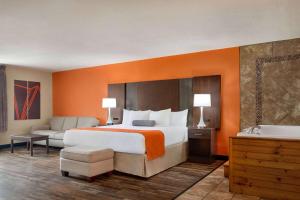 a hotel room with a large bed and a bath tub at Howard Johnson by Wyndham Pigeon Forge in Pigeon Forge +37 photos