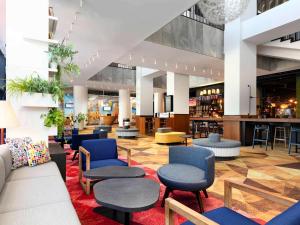 a lobby with chairs and tables and a bar at Ibis Poznan Centrum in Poznań