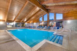 a large swimming pool in a house with a ceiling at AmericInn by Wyndham Dickinson in Dickinson