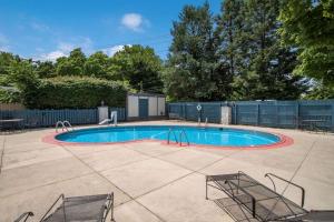 una piscina en un patio con 2 sillas alrededor en Rodeway Inn, en Carlisle