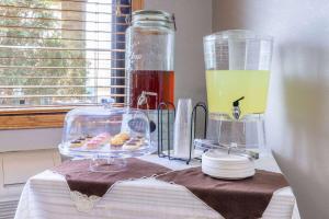 a table with a plate of donuts and a jar of juice at AmericInn by Wyndham Dickinson in Dickinson