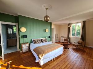 um quarto com uma cama e uma parede verde em La Terrasse de l'Estuaire - Honfleur em Honfleur