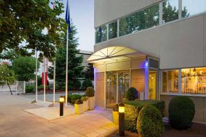 a facade of a building with lights in front of it at Ramada by Wyndham Madrid Tres Cantos in Tres Cantos