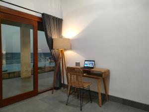 a desk with a laptop on it next to a window at Coco Blu Villa in Singaraja