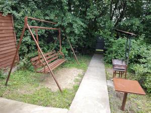 a swing and a chair sitting in a yard at Barbecue House in Vinnytsya
