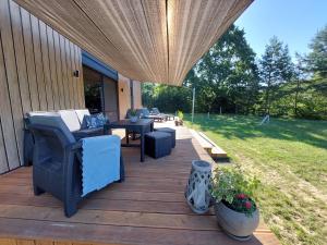 a wooden deck with chairs and tables on a house at Ekolandia in Orneta