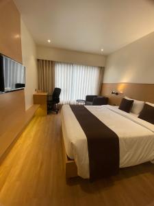 a hotel room with a bed and a flat screen tv at Hotel Mumbai House Ghansoli, Navi Mumbai in Navi Mumbai