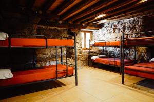 a room with three bunk beds in a stone wall at Cases Altes de Posada in Navés
