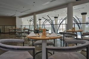 a restaurant with tables and chairs in a room at Marvelous Hotel in Tabuk