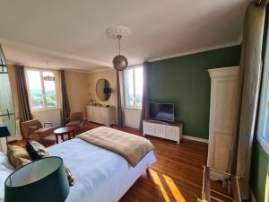 a bedroom with a large bed and a television at La Terrasse de l'Estuaire - Honfleur in Honfleur