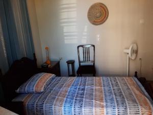 a bedroom with a bed with a blue comforter and a chair at Traditional Stone House with breathtaking view. in Zacharo