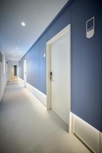 an empty corridor with blue walls and a door at Hotel Leonor Conil in Conil de la Frontera