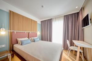 een slaapkamer met een groot wit bed en een bureau bij Hotel Leonor Conil in Conil de la Frontera