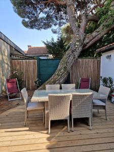 stół i krzesła na tarasie z drzewem w obiekcie Villa Bagatelle à 300m de la plage centrale, 3 chambres w Arcachon
