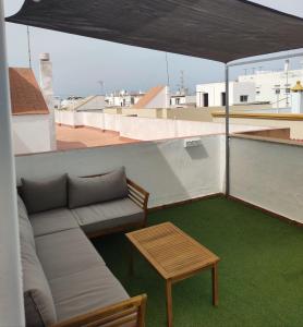 un sofá y una mesa en el techo en La Terraza de Natipao, en Rota