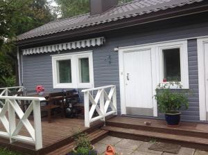 a gray house with a wooden deck with a table at Aurora Center 3 in Rovaniemi