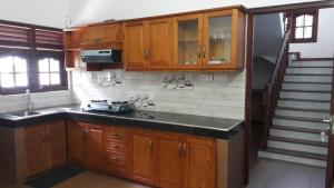 a kitchen with wooden cabinets and a counter top at Sun Set Forest Villa in Kandy