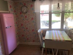 a kitchen with a table and a pink refrigerator at Skogsgläntan in Näsum