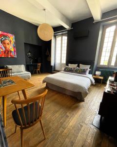 塔布的住宿－La Maison aux murs anciens et ses chambres，卧室配有一张床和一张桌子及椅子
