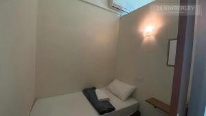 a small white room with a bed and a light at 24 Kimberley in George Town