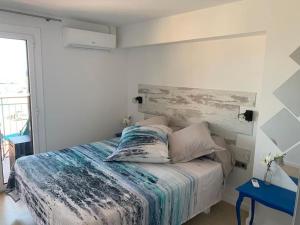 1 dormitorio con cama y mesa azul en La Casa De Papou I, en Sant Feliu de Guíxols