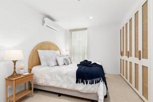Un dormitorio blanco con una cama grande y una mesa en LUXE @ THE TERRACE- BRAND NEW, 250M- BEACH + TOWN!, en Ocean Grove