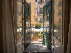 ein offenes Fenster mit Blick auf einen Balkon in der Unterkunft Kalamarina Rooms in Palermo