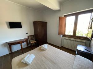 a bedroom with a bed and a desk and a window at Agriturismo Cupello in Cagnano Amiterno